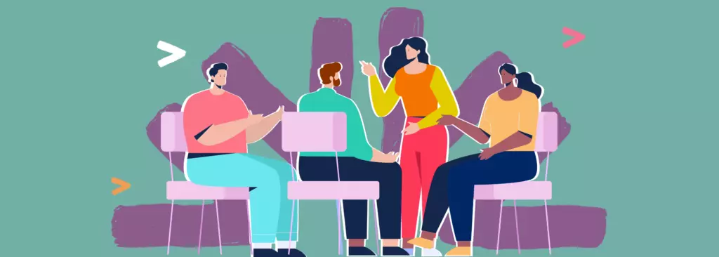 A woman stands speaking in a group discussion set in a community-style space, while participants sit and contribute ideas, reflecting adults gaining emotional readiness to recognize and respond to childhood sexual violence.